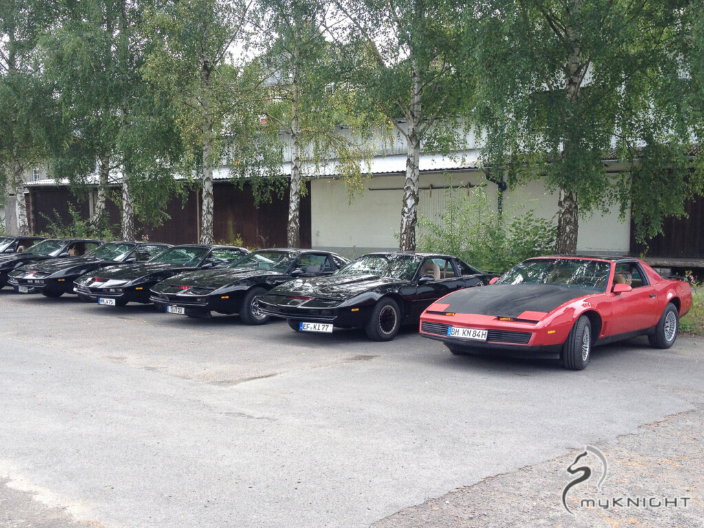Ein roter Pontiac Firebird Trans Am und eine Auswahl von K.I.T.T.-Repliken auf einem Parkplatz in Elspe